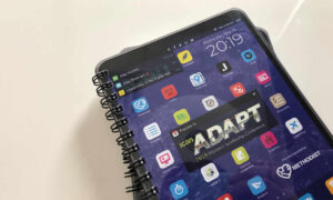 A spiral-bound notebook featuring an ICAN Adapt conference design styled like a tablet screen.