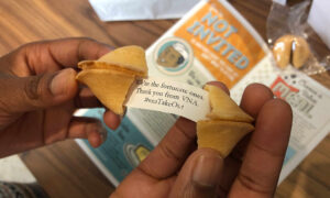 Hands opening a fortune cookie with a message thanking supporters from VNA.